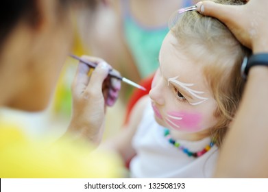 Adorable girl getting her face painted
