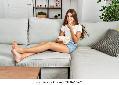 Adorable girl watching movie sitting on sofa at home - Shutterstock ID 2189615761
