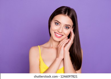 Adorable Good-looking Lady Make Her White Beaming Hollywood Smile She Look At Camera Stand Isolated On Vivid Violet Background Wear In Yellow Top Touch Face By Hand