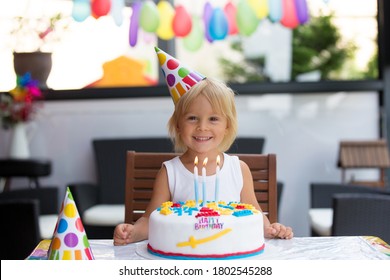 Adorable niño feliz, niño pequeño celebrando su cumpleaños en casa con globos, hermanos y coloridas tartas caseras