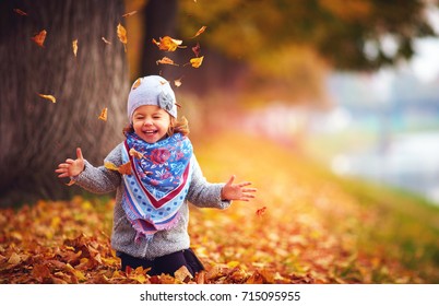 adorable happy girl playing with fallen leaves in autumn park - Powered by Shutterstock