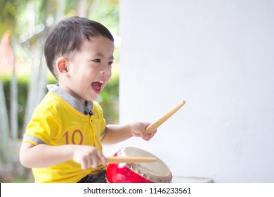 The Adorable Happy Little Asian Boy Playing An Hit The Drum At Home.Happy Kids.Child Development Concept.