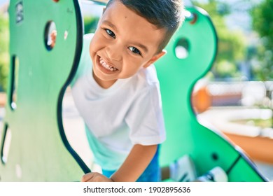 Adorable hispanic boy smiling happy playing at the park.