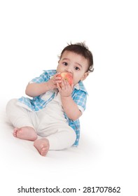 Adorable Indian Baby Boy Eating Apple Over White Background