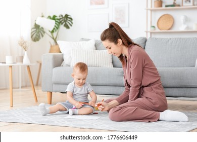 Adorable Infant Baby And His Mom Drawing With Pencils At Home Together  Relaxing On Floor In Living Room