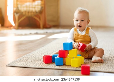 Adorable Infant Baby Playing With Stacking Building Blocks At Home While Sitting On Carpet In Living Room, Portrait Of Cute Caucasian Toddler Child Using Colorful Constructor Toys, Copy Space - Powered by Shutterstock