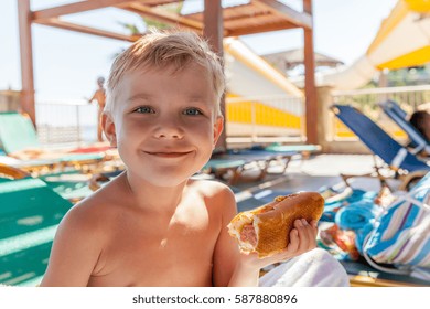 Adorable Kid Boy Eating Hot Dog At The Beach Aquapark