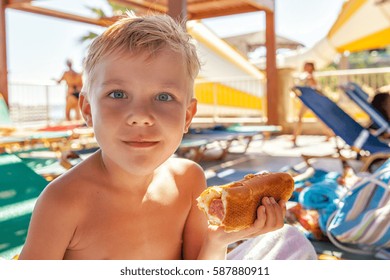 Adorable Kid Boy Eating Hot Dog At The Beach Aquapark