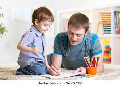 Adorable Kid Child And His Dad Drawing With Color Pencils