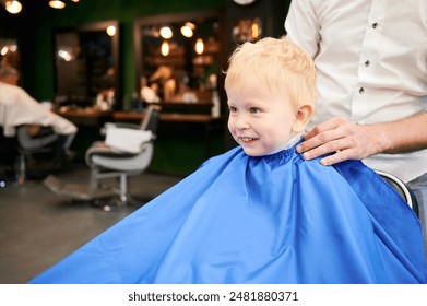 Adorable kid excited about new haircut. Little boy first time in barbershop. Cute client waiting for hairdresser. - Powered by Shutterstock