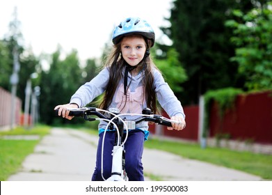 Adorable Kid Girl In Blue Helmet Riding Her Bike 