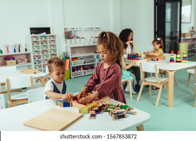 Adorable Kids Sitting At A School Desk And Playing With Toys