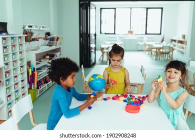 Adorable Kids Sitting At A School Desk And Playing