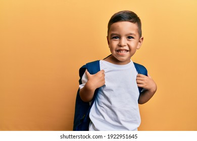 Adorable latin toddler smiling happy wearing student backpack over isolated yellow background. - Powered by Shutterstock