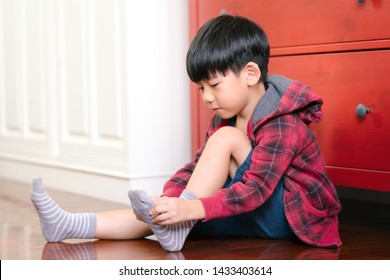 An Adorable Little Asian Boy Putting On Socks, Getting Ready For School. Montessori Practical Life Skills, Self-care, Child Development, Fine Motor, Hand Eye Coordination, Kids Daily Routine Concept.