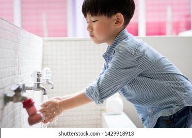 An Adorable Little Asian Boy Washing His Hands Before Lunch At The Wash Basin In The Kindergarten. Preventing Contagious Diseases, Plague. Kids Health, Hygiene And Hand Washing. Saving Water.