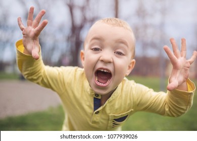 Adorable kleine Junge mit Spaß auf dem Spielplatz. Aktive Sportmöglichkeiten für Kinder im Freien im Park. Kleiner Junge mit blauen Augen in gelbem Hemd spielen und Spaß auf dem Spielplatz.
