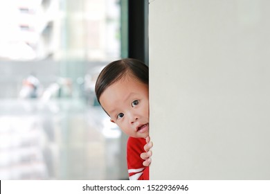 Adorable Little Boy Hide Behind A Corner Room. Baby Playing Peekaboo Game Indoor.