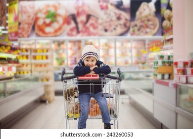 Adorable little boy, sitting in a shopping cart, smiling