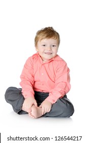 Adorable little boy smiling, sitting on the floor, studio shot, isolated on white background