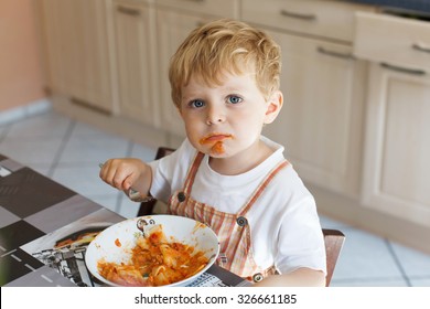 Adorable Little Boy Two Years Eating Pasta Indoor. Toddler Child In Domestic Kitchen Or In Nursery. Cute Kid And Healthy Food.