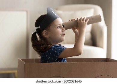 Adorable Little Caucasian Girl In Pirate Hat Looking In Spyglass, Cute Preschool Child Kid Wearing Homemade Costume Holding Cardboard Tube As Telescope Sitting In Toy Ship, Playing Funny Game