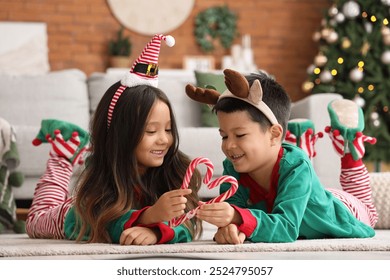 Adorable little children with candy canes on Christmas eve at home - Powered by Shutterstock