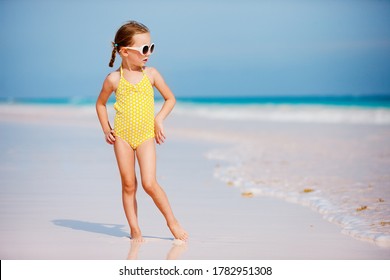 Adorable little girl at beach enjoyong tropical summer vacation