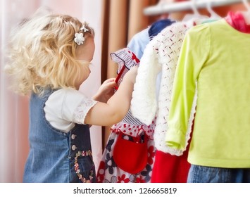 Adorable Little Girl Choosing Clothes