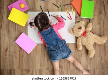 Adorable Little Girl Drawing Artwork. Studio Shot Top View Of Child On Floor