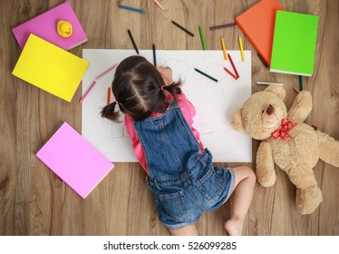 Adorable little girl drawing artwork top view on floor, Baby healthy and preschool concept - Powered by Shutterstock