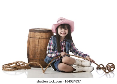 Adorable little girl dressed as a cowgirl.  Isolated on white.