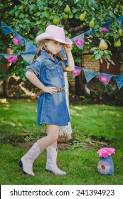 Adorable little girl dressed as a cowgirl outdoors