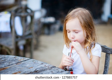 Adorable Little Girl Drinking With A Straw A Soft Drink