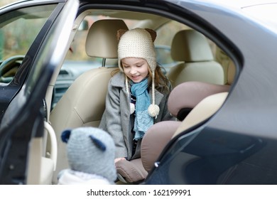 Adorable Little Girl Getting Into Her Car Seat