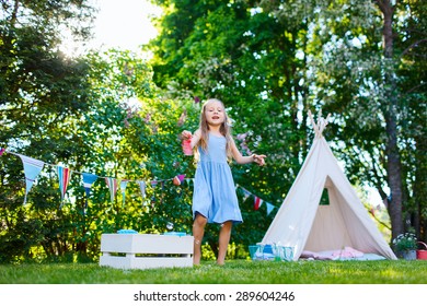 Adorable little girl having fun playing outdoors on summer day