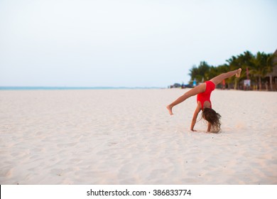 Adorable little girl having fun making cartwheel on tropical white sandy beach - Powered by Shutterstock