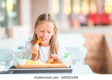 Adorable little girl having tasty dinner at outdoor cafe - Shutterstock ID 1493315204