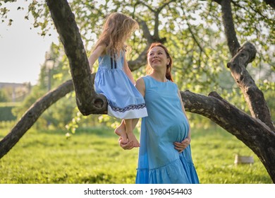 Adorable Little Girl And Her Pregnant Mom Enjoying Her Time In Park On Warm And Sunny Summer Day. Child Having Fun On School Vacations.