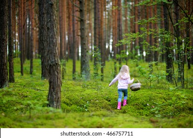 Adorable little girl picking foxberries in the forest on summer day - Powered by Shutterstock