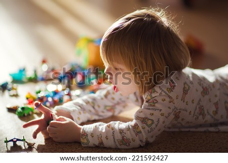 Similar – Baby Mädchen spielt mit Haarspangen, die auf dem Boden liegen.