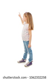 Adorable little girl pointing at wall. Isolated on white background 