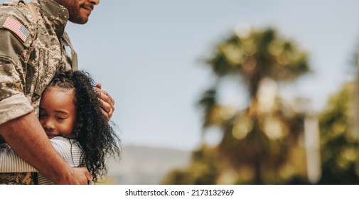 Adorable little girl reuniting with her military dad at home. Young girl embracing her father on his homecoming. Army soldier receiving a warm welcome from his child after deployment. - Powered by Shutterstock