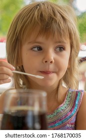 Adorable Little Girl With A Small Plastic Coffee Spoon