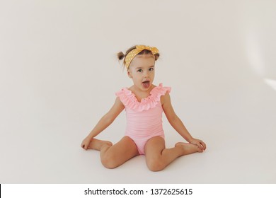 Adorable little girl waiting summer vacation. Cute playful little girl in swimsuit isolated on a white