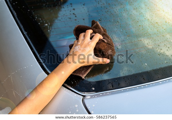 Adorable little girl washing a car on a car wash on\
sunny summer day.Happy Asian girl washing car on water splashing\
and sunlight at home. Useful Activities for kids.The hand of a\
child washing a car