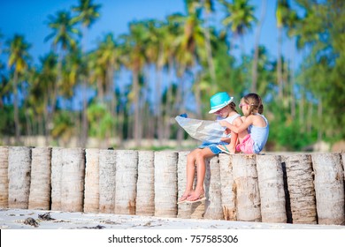 Adorable little girls with map of island on beach