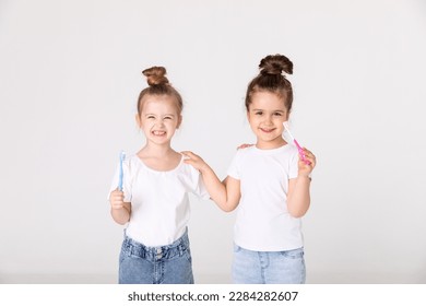 Adorable little girls with tooth brushes. Fun home play. Children smile. Healthy lifestyle, not afraid of dentist. Health care, dental hygiene - Powered by Shutterstock