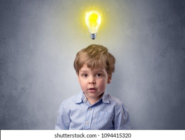 Adorable little kid mull over in front of a grey wall with idea symbol above his head - Shutterstock ID 1094415320