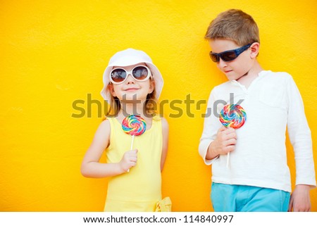 Adorable little kids with colorful lollipops